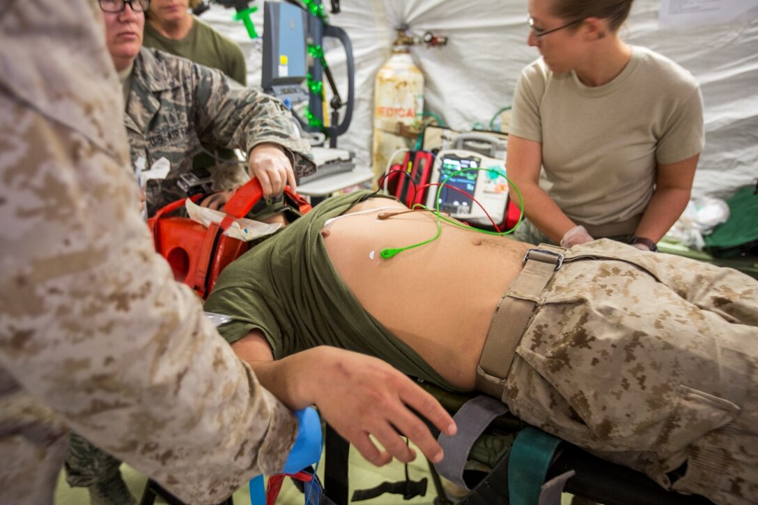 U.S. Joint Forces and U.S. Navy Corpsmen with Special Purpose Marine Air-Ground Task Force-Crisis Response-Central Command (SPMAGTF-CR-CC) provide medical aid to Cpl. Galton Hua, a simulated casualty, with Charlie Co., 1st Battalion, 7th Marine Regiment, SPMAGTF-CR-CC, during a mass casualty exercise at an undisclosed location in Southwest Asia, Dec. 23, 2015.  The training familiarized U.S. joint services and partner nations with various techniques and procedures while simultaneously handling multiple casualties. (U.S. Marine Corps photo by Lance Cpl. Clarence Leake/Released)