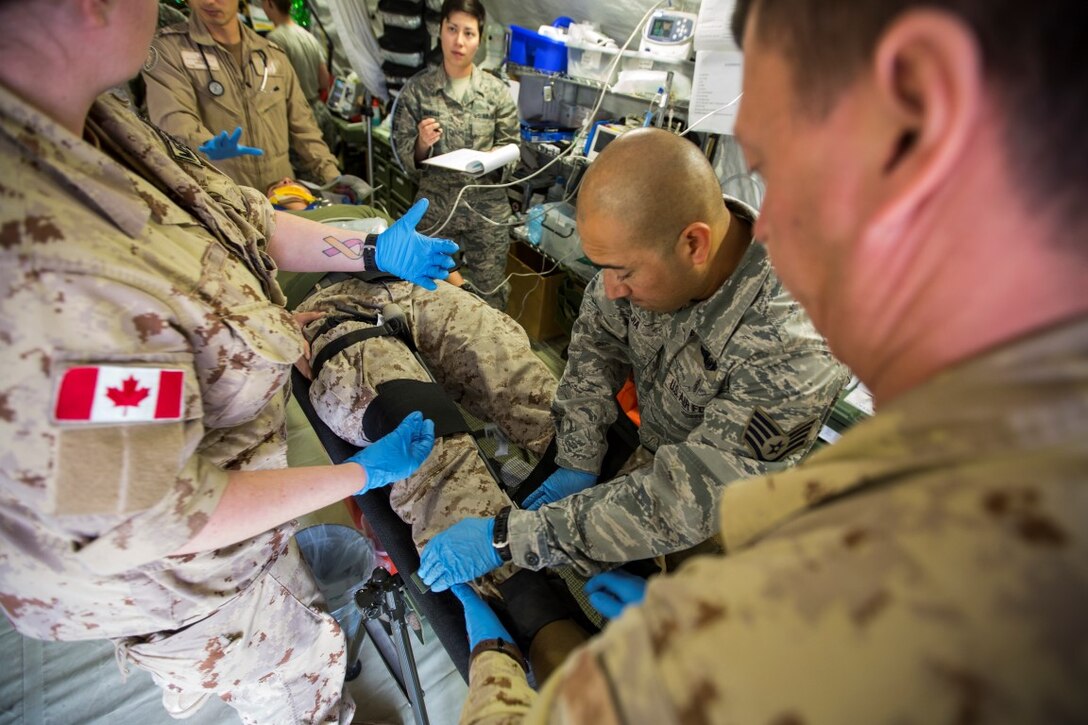 Coalition medical personnel treat a simulated casualty during a mass casualty exercise at an undisclosed location in Southwest Asia, Dec. 23, 2015. The training familiarized U.S. joint services and partner nations with various techniques and procedures while simultaneously handling multiple casualties. (U.S. Marine Corps photo by Lance Cpl. Clarence Leake/Released)