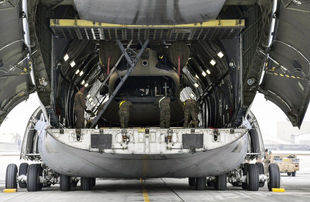 U.S. soldiers and airmen unload a helicopter from a C-5M Super Galaxy on Bagram Airfield, Afghanistan, Dec. 26, 2015. U.S. Air Force photo by Tech. Sgt. Nicholas Rau 