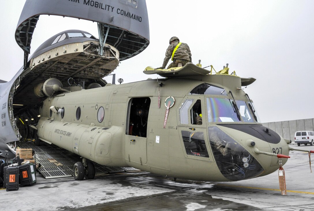 U.S. soldiers and airmen unload a CH-47 Chinook helicopter from a C-5M Super Galaxy on Bagram Airfield, Afghanistan, Dec. 26, 2015. U.S. Air Force photo by Tech. Sgt. Nicholas Rau 