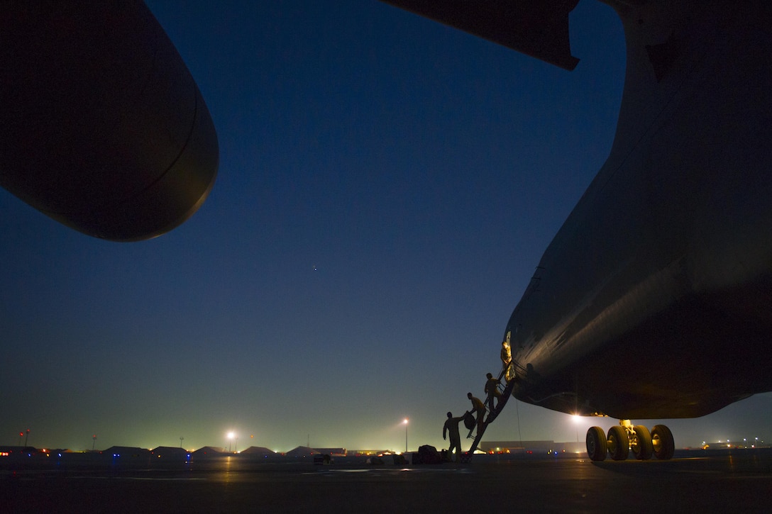 U.S. airmen load bags onto a C-5 Galaxy as it sits on the ramp at Bagram Airfield, Afghanistan, Dec. 28, 2015. The airmen are flight crew members deployed from Travis Air Force Base, California. U.S. Air Force photo by Tech. Sgt. Robert Cloy 