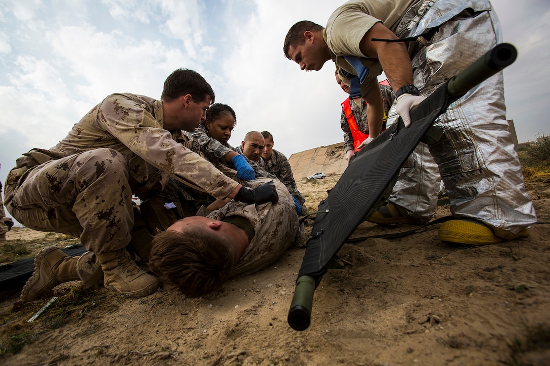 U.S. Navy and Air Force medical personnel load a simulated patient onto a stretcher during a mass casualty exercise at an undisclosed location in Southwest Asia, Dec. 23, 2015. U.S. Marine Corps Photo by Sgt. Rick Hurtado 