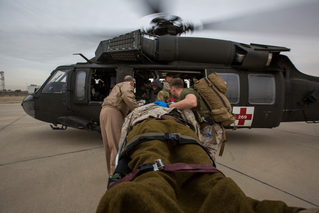 U.S. Navy Corpsmen with Special Purpose Marine Air-Ground Task Force-Crisis Response-Central Command (SPMAGTF-CR-CC) transport Cpl. Galton Hua, a simulated casualty, with Charlie Co., 1st Battalion, 7th Marine Regiment, SPMAGTF-CR-CC, to a U.S. Army UH-60 Blackhawk aircraft for air evacuation during a mass casualty exercise at an undisclosed location in Southwest Asia, Dec. 23, 2015. The training familiarized U.S. joint services and partner nations with various techniques and procedures while simultaneously handling multiple casualties. (U.S. Marine Corps photo by Lance Cpl. Clarence Leake/Released)