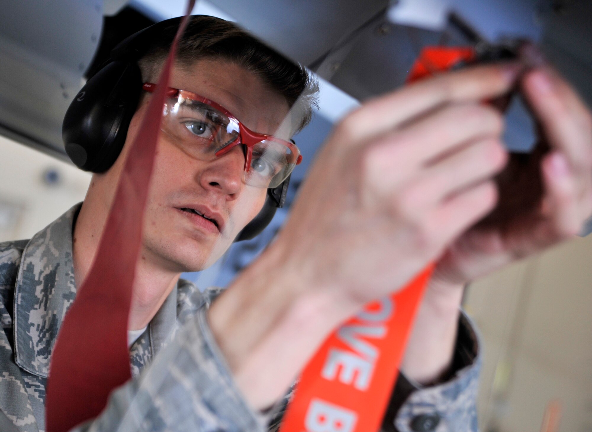 Airman 1st Class Kenneth Rogers, 432nd Aircraft Maintenance Squadron weapons load crew member, safety-wires an inert GBU-12 Paveway II laser-guided bomb  on an MQ-9 Reaper during the 432nd Maintenance Group Load Crew of the Year competition Feb. 13, 2015, at Creech Air Force Base, Nevada. This year the teams were graded on loading four inert GBU-12 Paveway II laser-guided bombs on an MQ-9 Reaper in under 45 minutes while committing as few discrepancies as possible. (U.S. Air Force photo by Airman 1st Class Christian Clausen/Released)