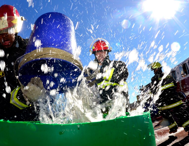 A team of participants complete the 'bucket brigade' as part of the 5th annual Fire Muster Oct. 9, 2015, at Creech Air Force Base, Nevada. Over 12 teams competed in the event, which aims to spread fire prevention awareness through a series of firefighter related challenges. (U.S. Air Force photo by Airman 1st Class Christian Clausen/Released)
