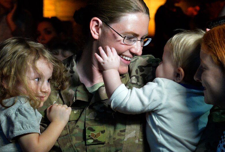 Staff Sgt. Julie Mauldin, a crew chief with the 432nd Aircraft Maintenance Squadron, hugs her children after surprising them with an early homecoming from a deployment to Southwest Asia, Feb. 13, 2015 at the Shark Reef Aquarium in Las Vegas. As Mauldin surprised her family, aquarium patrons erupted in applause. (U.S. Air Force photo by Senior Airman Adarius Petty/Released)