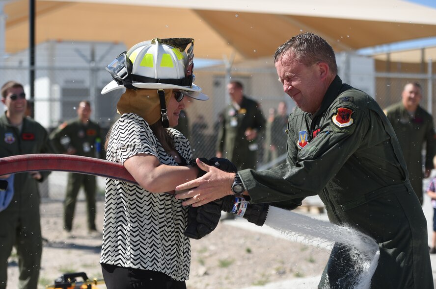 Col. James Cluff, 432nd Wing/432nd Air Expeditionary Wing commander, gets sprayed by his wife and fellow Airmen following his final flight with the wing May 28th, 2015, on Creech Air Force Base, Nevada. The tradition of fini-flights can trace its roots back to the U.S. Army Air Force days of World War II ear. (U.S. Air Force photo by Tech. Sgt. Nadine Barclay/Released)