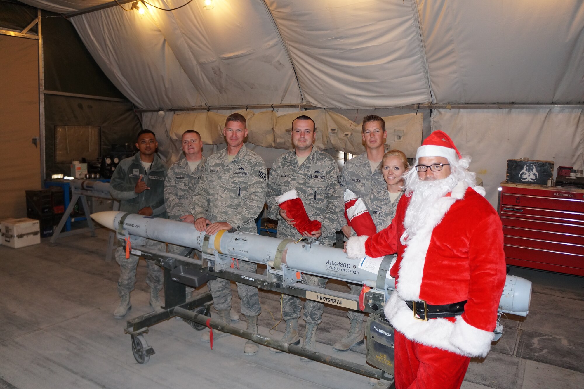 Members of the 380th Expeditionary Maintenance Squadron enjoy a visit from Santa, played by Chief Master Sgt. William, who handed out filled stockings to the troops at an undisclosed location in Southwest Asia on Christmas. When he’s not deployed, “Santa” makes his home at the 916th Air Refueling Wing, Seymour Johnson Air Force Base, North Carolina. (U.S. Air Force/courtesy photo)