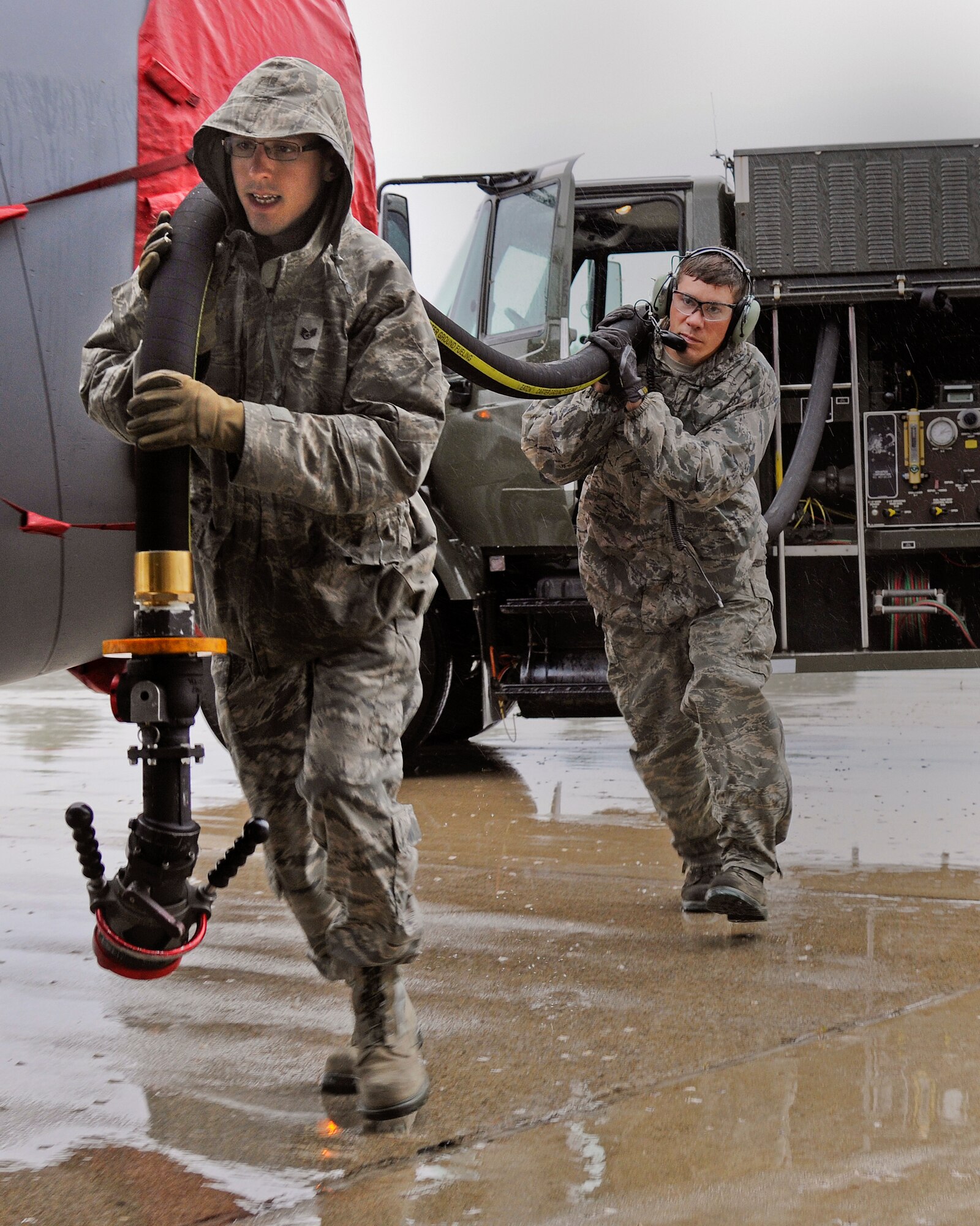 Staff Sgt. Daniel Vergun, 127th Logistics Readiness Squadron fuels technician, and Staff Sgt. Jesse Torma, 191st Maintenance Squadron crew chief, carry the fuel hose to a KC-135 Stratotanker on the flightline at Selfridge Air National Guard Base, Mich., July 9, 2015. Fully loaded, a KC-135 can hold up to 203,000 pounds of fuel. On a typical day, the average load is around 40,000 pounds or 5,900 gallons of fuel. (U.S. Air National Guard Photo by Senior Airman Ryan Zeski/Released)