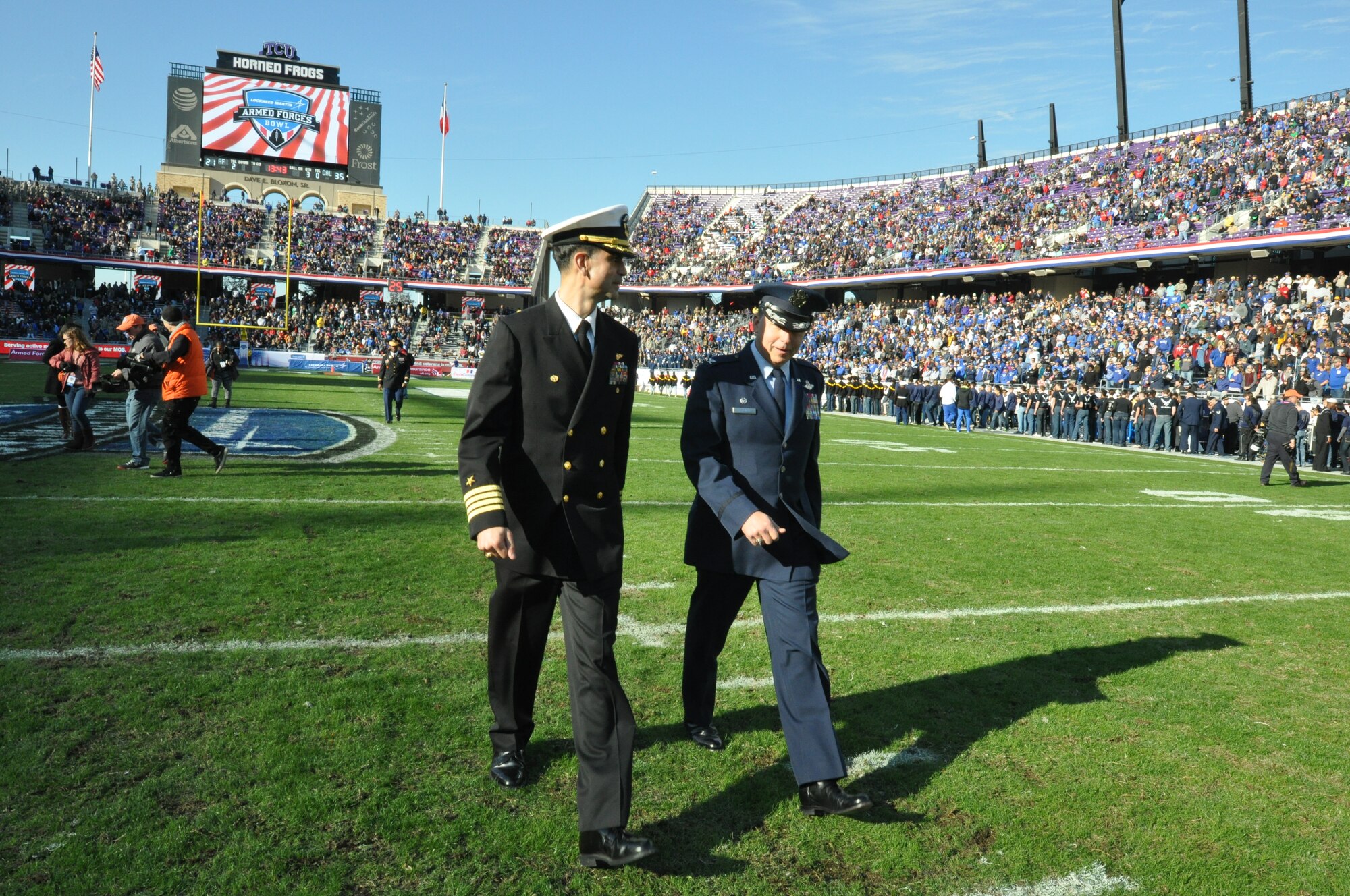 NAVAL AIR STATION FORT WORTH JOINT RESERVE BASE, Texas - Navy Capt. Mike Steffen, commanding officer of Naval Air Station Fort Worth Joint Reserve Base, and Air Force Col. John Breazeale, 301st Fighter Wing commander, walk across the field Dec. 29 after participating in a mass enlistment at the Lockheed Martin Armed Forces Bowl at Amon G. Carter stadium, Fort Worth, Texas. During the game the U.S. Air Force Academy and the University of California battled for the championship, but in the end the Bears beat the Falcons 55 to 36. (U.S. Air Force photo by Master Sgt. Julie Briden-Garcia)