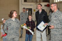 Tech. Sgt. Carly Smith, 22nd Maintenance Squadron munitions operations NCO in charge, and her family listen to Col. Phil Heseltine, 22nd Air Refueling Wing  vice commander, explain her selection for promotion to technical sergeant, Dec. 23, 2015, at McConnell Air Force Base, Kan. Smith was the only Airman at McConnell AFB selected for promotion through the Stripes for Exceptional Program, which authorizes a select few Airmen in each major command to be promoted without testing one rank to either staff or technical at the recommendation of their commander. (U.S. Air Force photo/Senior Airman David Bernal Del Agua)