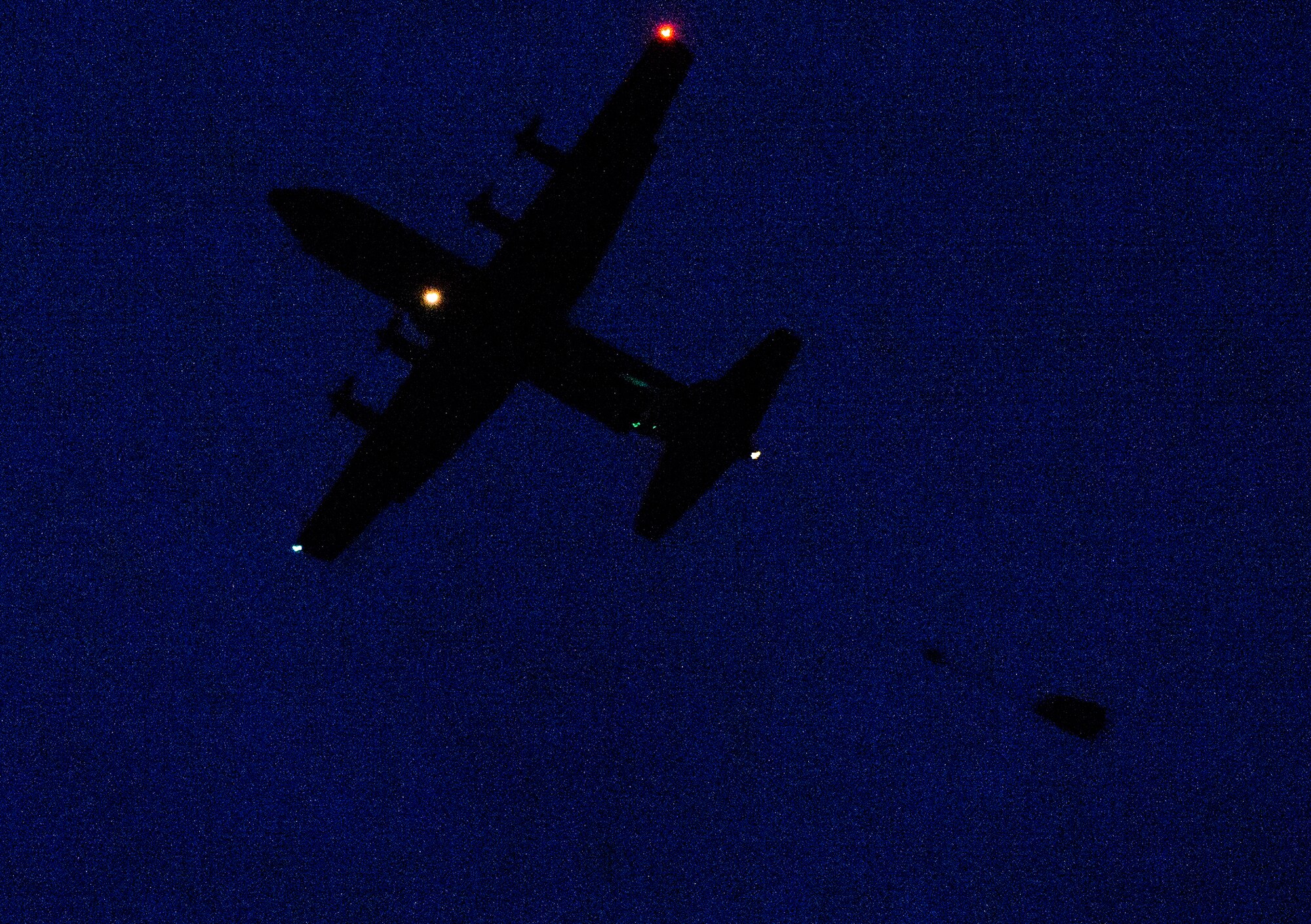 Airmen and Soldiers jump out of a C-130J Super Hercules during a nighttime training scenario Dec. 18, 2015, at the Alzey Drop Zone, Germany. As the paratroopers descended, they were greeted by the 435th Contingency Response Support Squadron independent duty medical technicians. The IDMTs operate with the 435th Contingency Response Group forces and were on scene in case of any medical emergencies. (U.S. Air Force photo/Staff Sgt. Armando A. Schwier-Morales)