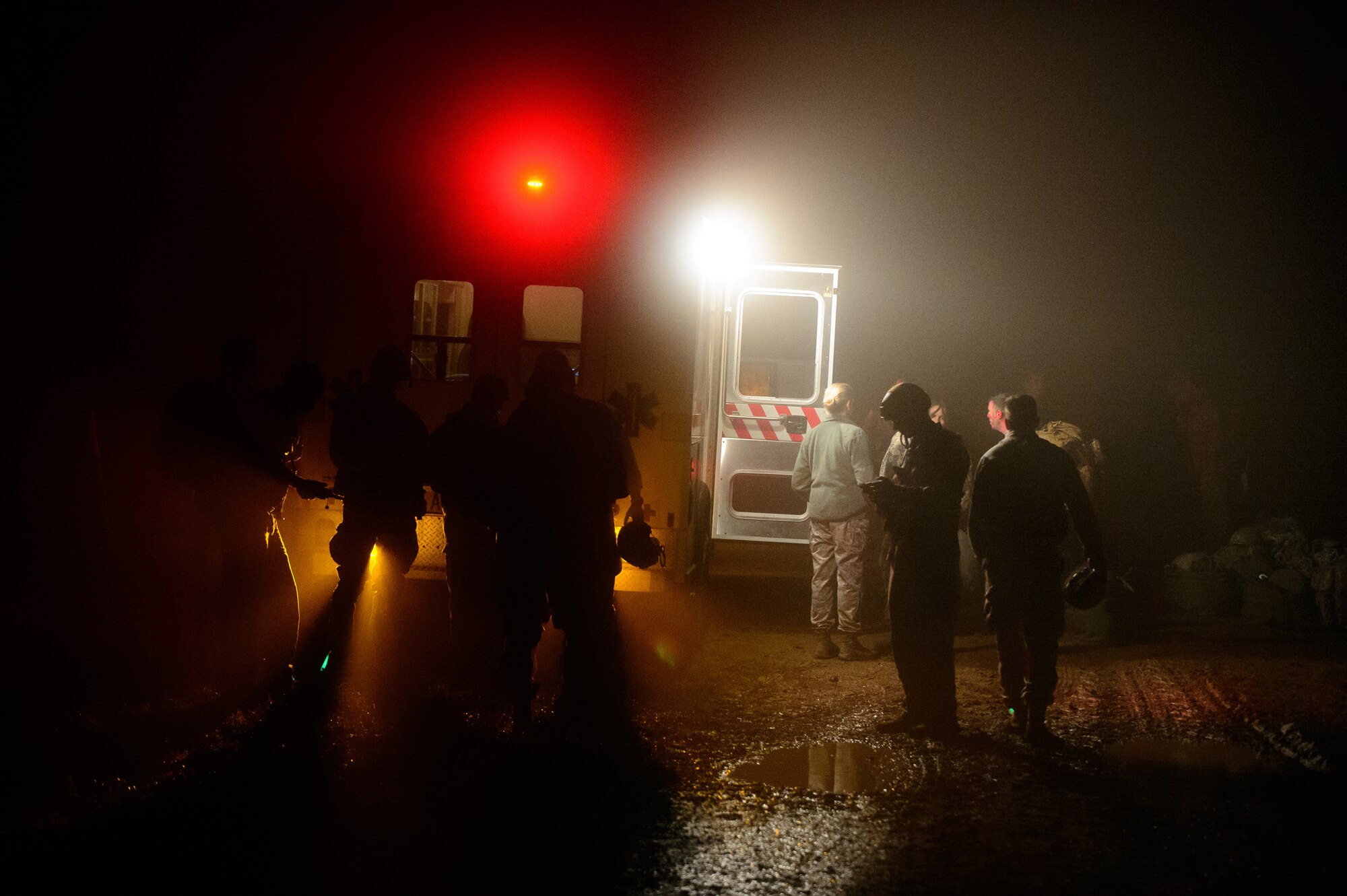 Members of the 435th Air Ground Operations Wing gather near an ambulance during a nighttime training jump Dec. 18, 2015, at Alzey Drop Zone, Germany. Medics from the 435th AGOW waited for their fellow Airmen who dropped with paratroopers in case of an emergency. (U.S. Air Force photo/Staff Sgt. Armando A. Schwier-Morales)