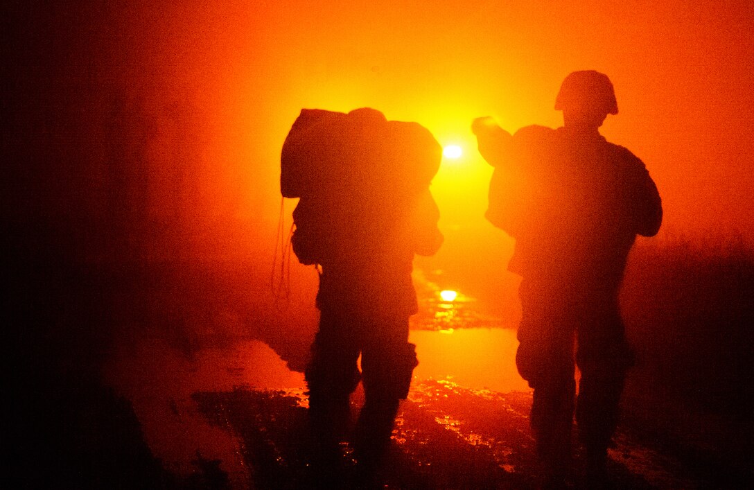 Two Soldiers walk towards an ambulance after jumping from a C-130J Super Hercules Dec. 18, 2015, at Alzey Drop Zone, Germany. The two were part of night-time operations designed to improve not only the Army paratroopers but also the 435th Air Ground Operations Wing capabilities. (U.S. Air Force photo/Staff Sgt. Armando A. Schwier-Morales)