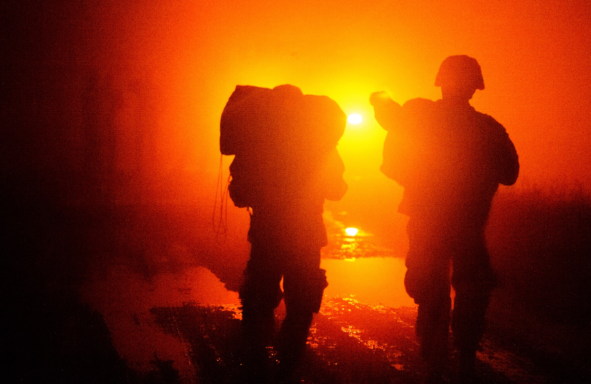 Two Soldiers walk towards an ambulance after jumping from a C-130J Super Hercules Dec. 18, 2015, at Alzey Drop Zone, Germany. The two were part of night-time operations designed to improve not only the Army paratroopers but also the 435th Air Ground Operations Wing capabilities. (U.S. Air Force photo/Staff Sgt. Armando A. Schwier-Morales)