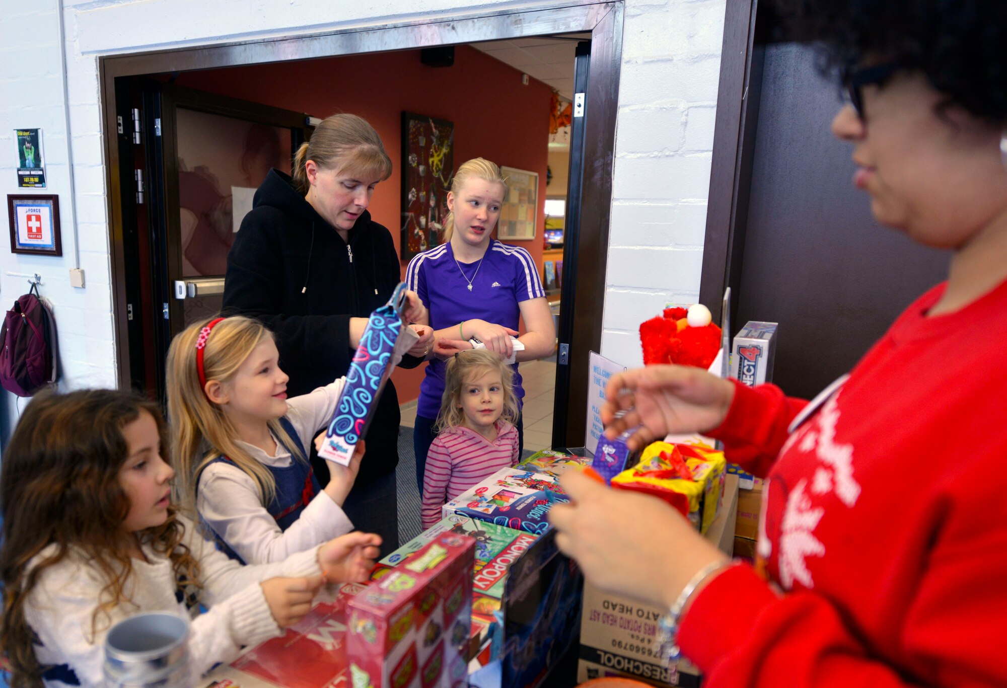 Children pick out gifts during a deployed family members event Dec. 21, 2015, at Vogelweh Military Complex, Germany. The Vogelweh Youth Program hosted the event, which aims to reduce the stress of deployments. In addition to food, games and movies, each child received a gift and portrait free of charge. (U.S. Air Force photo/Staff Sgt. Sharida Jackson)