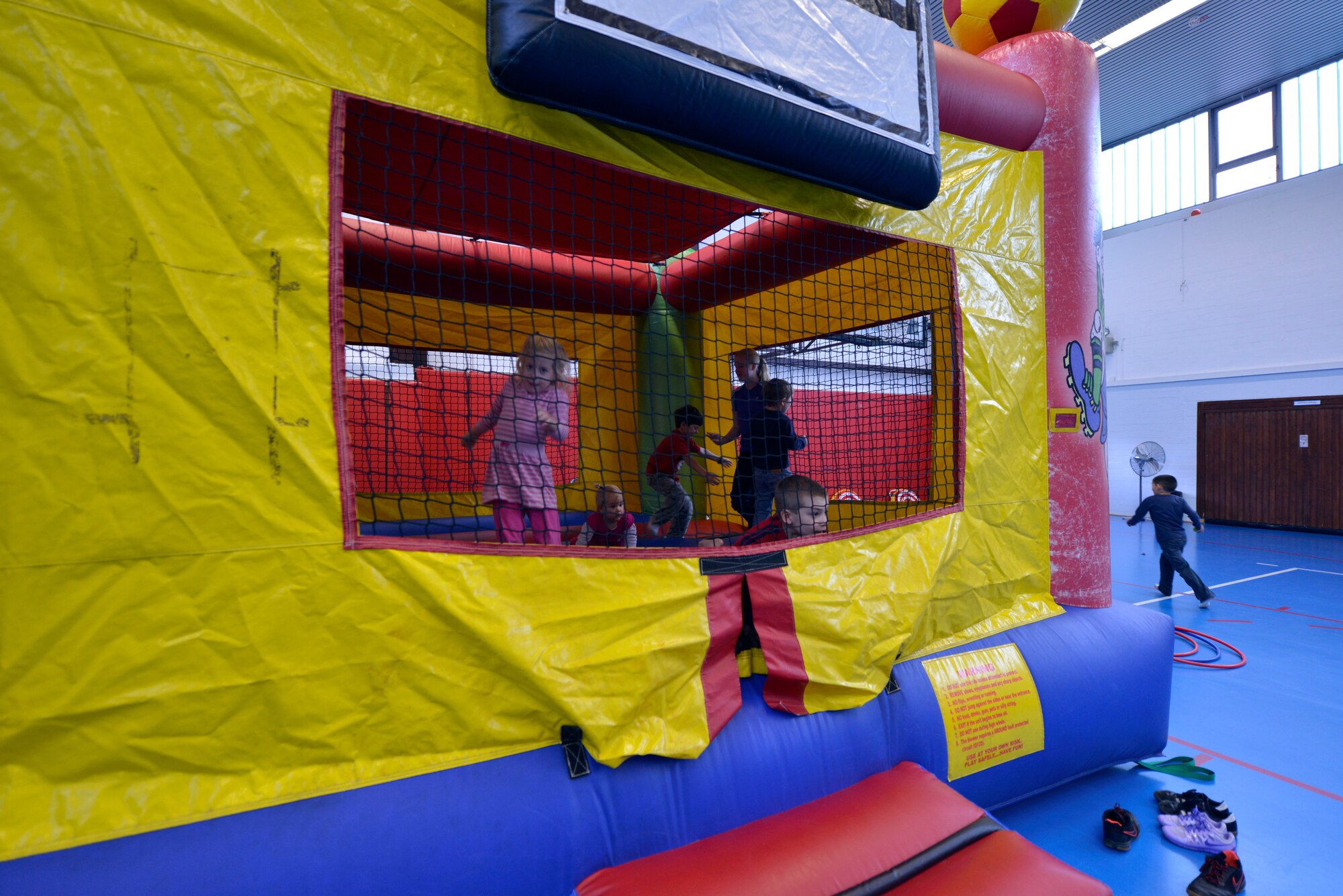 Children jump in a bouncy castle during the 2015 Deployed Family Members Winter Bash Dec. 21, 2015, at Vogelweh Military Complex, Germany. The event included food, games, movies and a gift give-a-way. (U.S. Air Force photo/Staff Sgt. Sharida Jackson)