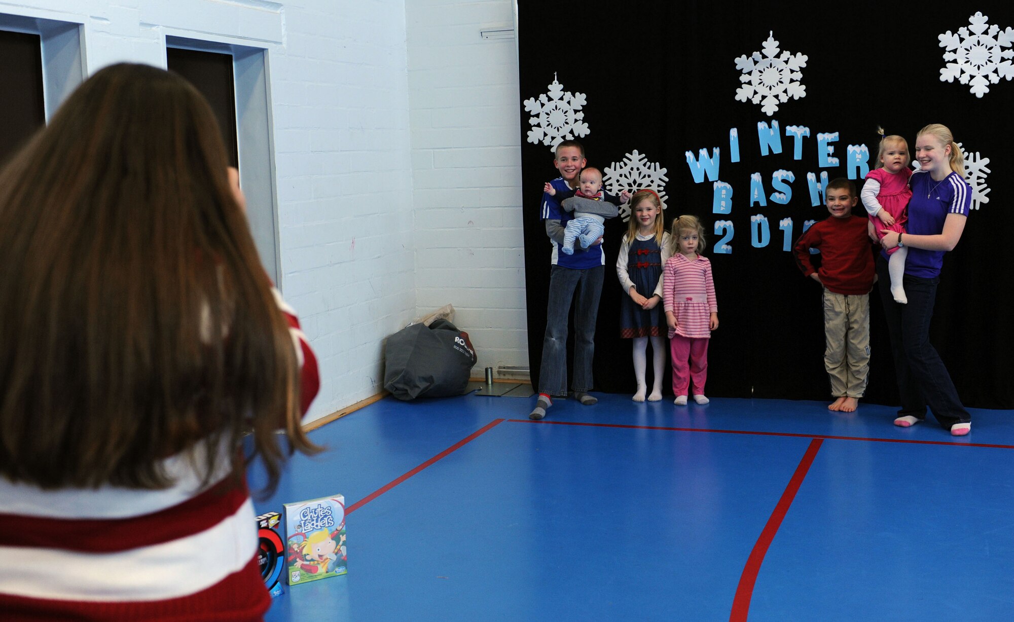 A member of the Vogelweh Youth Program takes a photo during the 2015 Deployed Family Members Winter Bash Dec. 21, 2015, at Vogelweh Military Complex, Germany. During the event, each family received a portrait free of charge. (U.S. Air Force photo/Staff Sgt. Sharida Jackson)