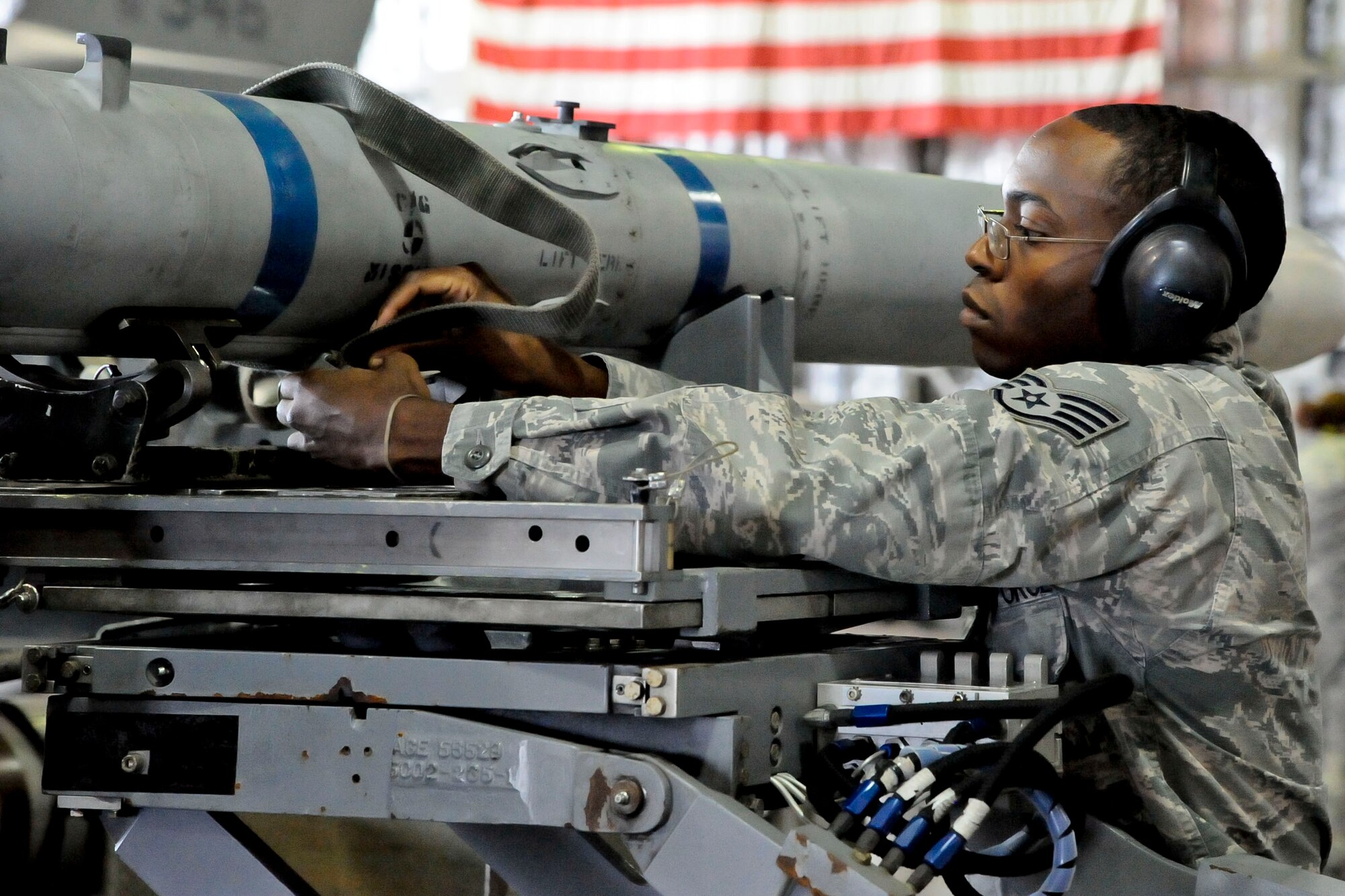 U.S Air Force Staff Sgt. Mekai Stewart, 35th Aircraft Maintenance Squadron, 14th Aircraft Maintenance Unit weapons team chief, secures a harness on a set of armaments during a quarterly load crew competition at Misawa Air Base, Japan, Dec. 30, 2015. Stewart was the senior member of his team of three and was charged with inspecting the quality and efficiency of his team’s work during the 30-minute-long competition. (U.S. Air Force photo by Senior Airman Patrick S. Ciccarone/Released)
