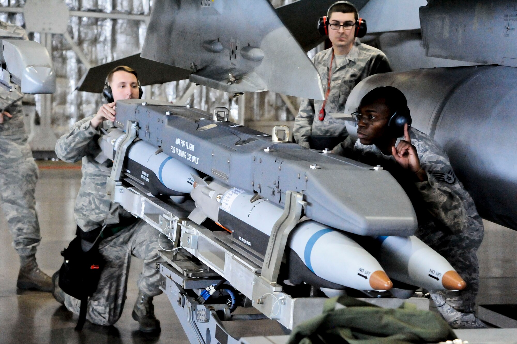 U.S Air Force Staff Sgt. Mekai Stewart, 35th Aircraft Maintenance Squadron, 14th Aircraft Maintenance Unit weapons team chief, awaits the alignment of a weapons system at Misawa Air Base, Japan, Dec. 30, 2015. Stewart and his team were competing in a weapons load crew competition. Normally, teams of three Airmen are challenged to quickly install upwards of three types of armaments to a stationary F-16 Fighting Falcon in the quickest time possible. (U.S. Air Force photo by Senior Airman Patrick S. Ciccarone/Released)