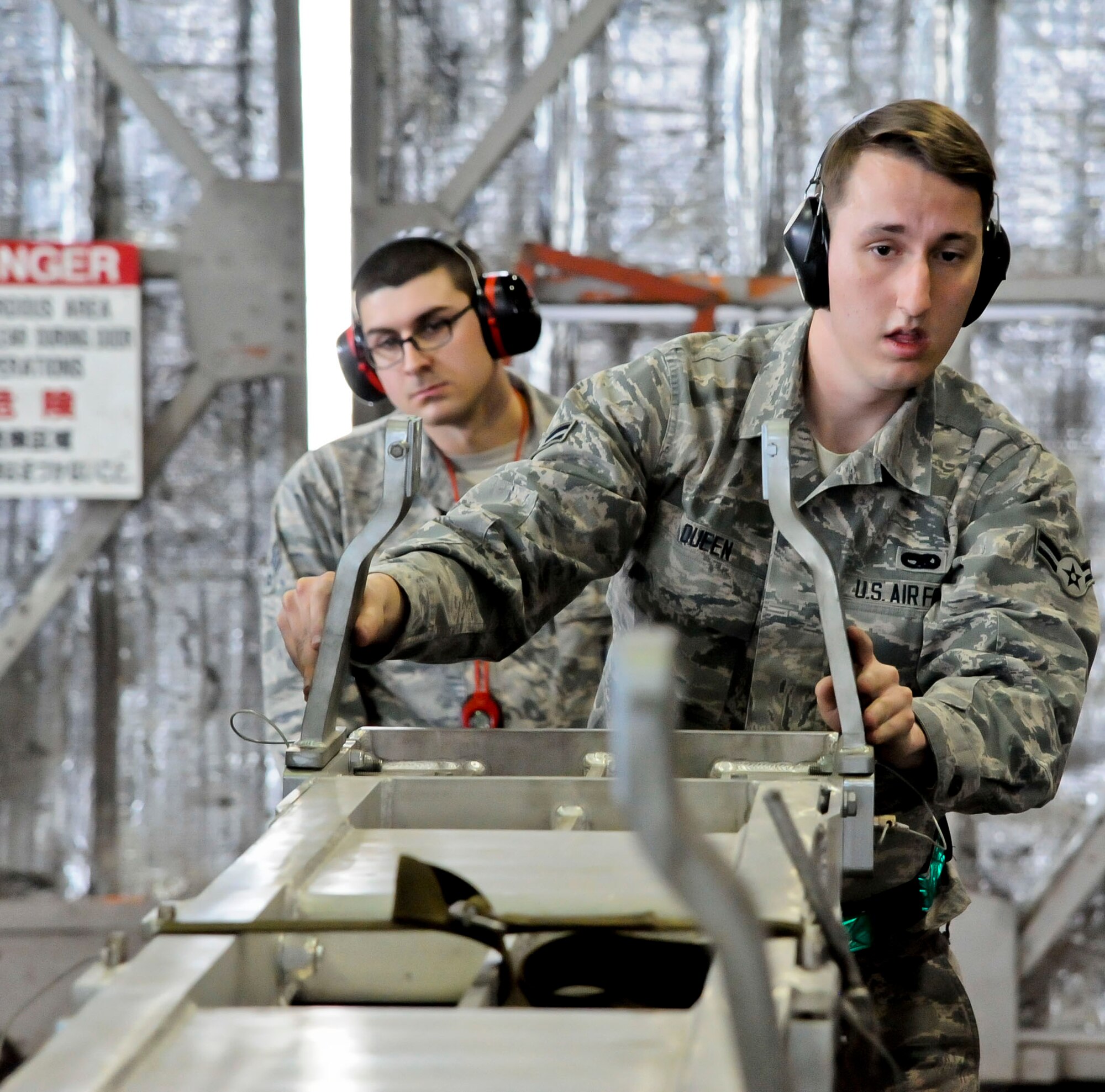 U.S. Air Force Airman 1st Class Dylan Queen, 35th Aircraft Maintenance Squadron, 14th Aircraft Maintenance Unit weapons load crew member, steadies an armament platform as Senior Airman Joshua Foster, 35th Maintenance Group standardization load crew member, observes during a quarterly load crew competition at Misawa Air Base, Japan, Dec. 30, 2015. The objective of the weapons load crew competition was to gauge how quickly and efficiently teams of Airmen are able to arm an F-16 Fighting Falcon. (U.S. Air Force photo by Senior Airman Patrick S. Ciccarone/Released) 