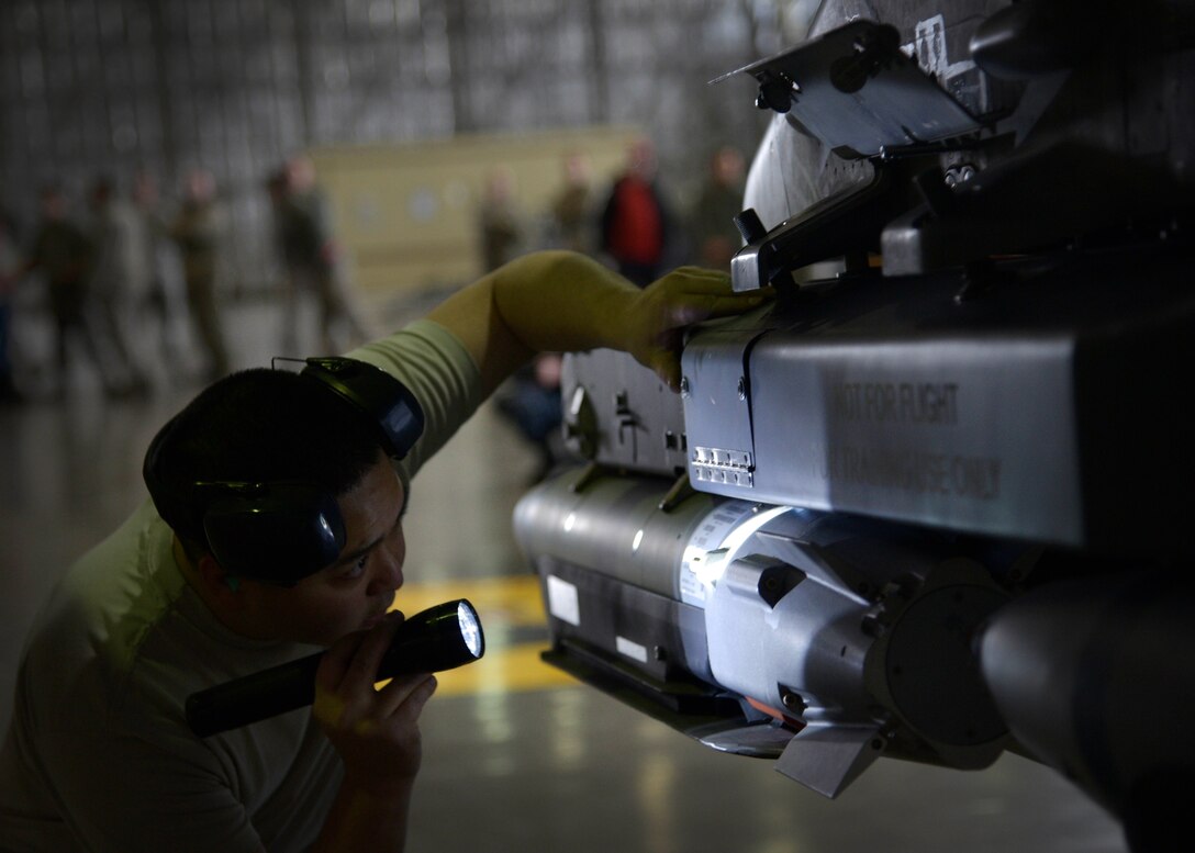 U.S. Air Force Staff Sgt. Nathan Hadama, 35th Aircraft Maintenance Squadron, 13th Aircraft Maintenance Unit weapons team chief, inspects a weapons system after it was loaded during a quarterly weapons loading competition at Misawa Air Base, Japan, Dec. 30, 2015. Hadama was the senior member of his team of three and was charged with inspecting the quality and efficiency of his team’s work during the 30-minute-long competition. (U.S. Air Force photo by Senior Airman Deana Heitzman/Released)    