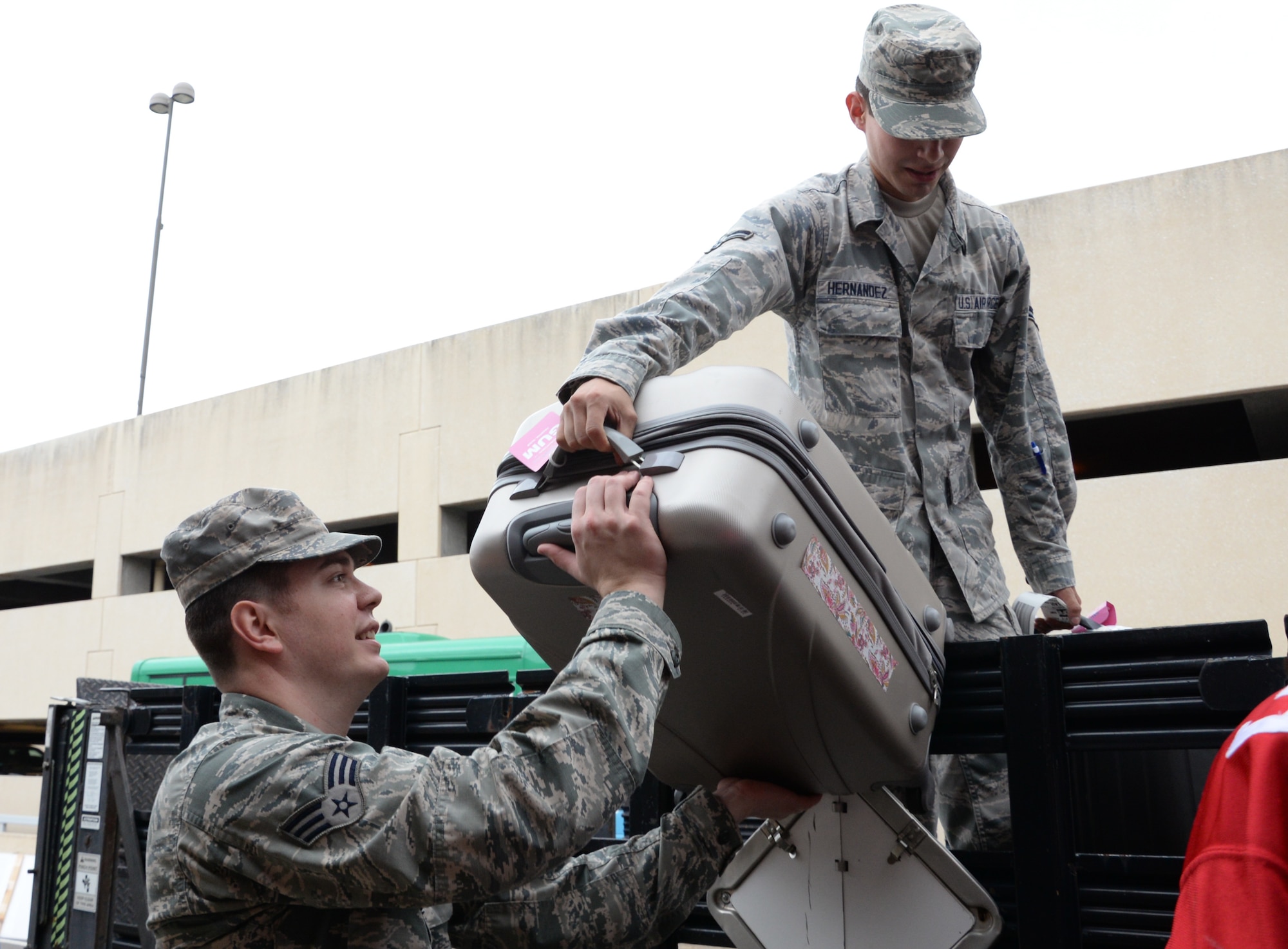 U.S. Air Force Senior Airman Joshua Simpson, a logistics specialist assigned to the 136th Logistics Readiness Squadron, Texas Air National Guard, and Airman 1st Class Valentin Hernandez, a security forces apprentice assigned to the 301st Security Forces Squadron both from Naval Air Station Fort Worth Joint Reserve Base, Texas, unload baggage for attendees of Snowball Express 2015 at Dallas-Fort Worth Airport, Dec. 12, 2015. Snowball Express is an organization dedicated to the children of military members who have died while on active duty since Sept. 11. (Air National Guard photo by Tech. Sgt. Vanessa Reed/released)