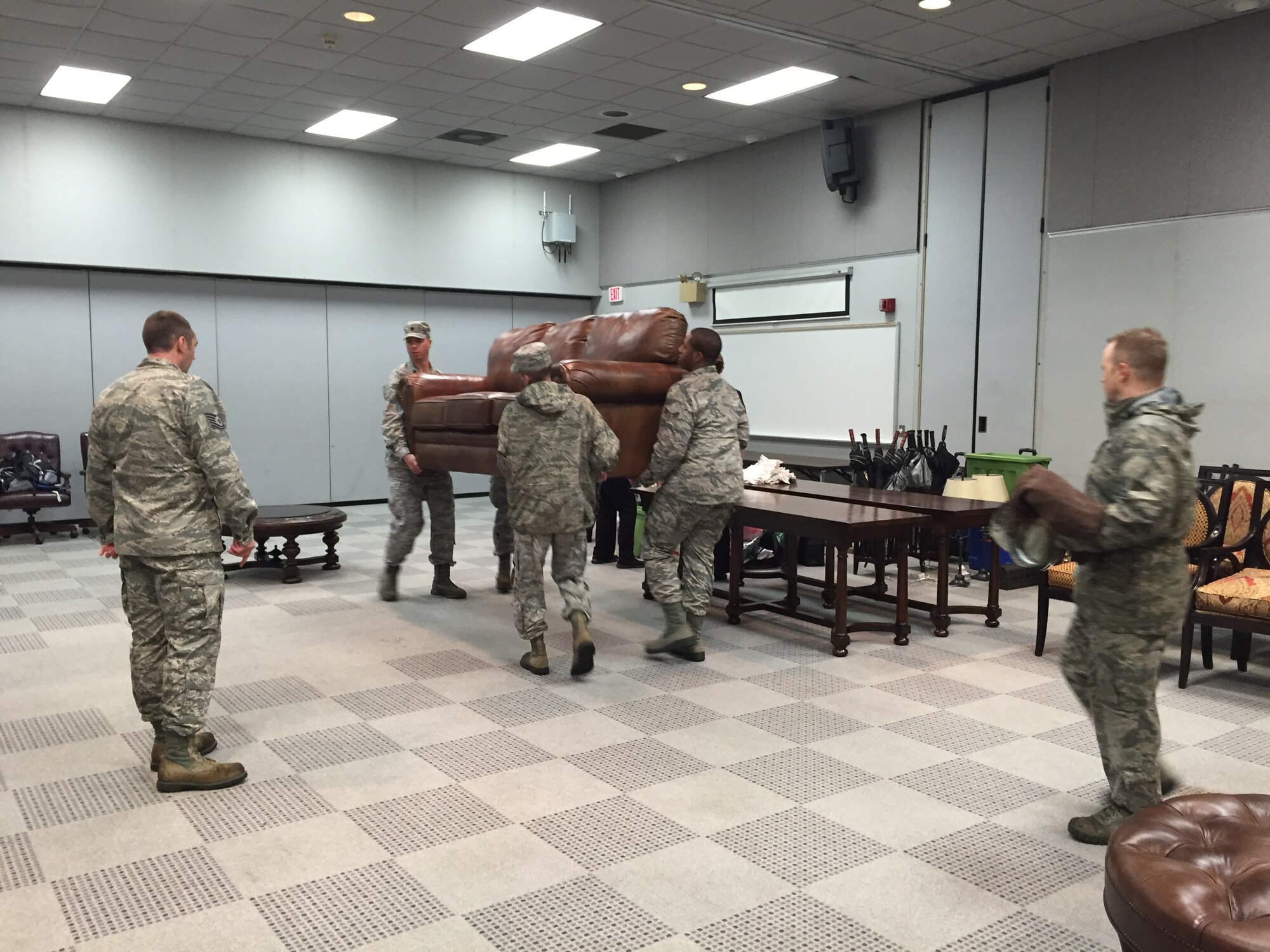 Delaware Air National Guard and Air Force Mortuary Affairs Operations personnel work together to create an area for families of the fallen in the Loffel Room of the Delaware Air National Guard Wing Headquarters Building, New Castle, Del., Dec. 23, 2015. The room was redesigned in a matter of hours when the dignified transfer mission diverted to the Guard Base due to weather. (U.S. Air Force photo/Roland Balik)