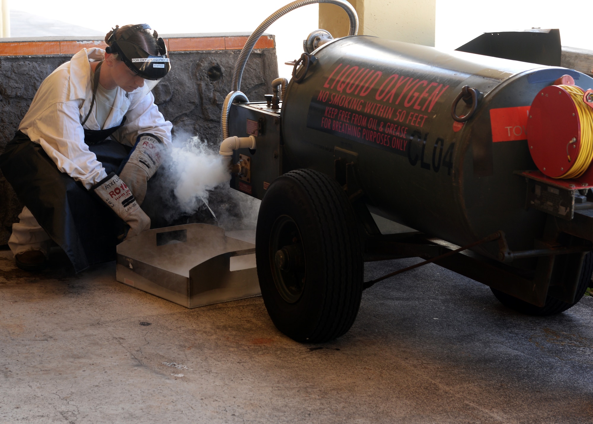 Senior Airman Laenya Maze, 36th Maintenance Squadron, electrical and environmental technician, releases built up pressure from a liquid oxygen cart Dec. 1, 2015 at Andersen Air Force Base, Guam.  On a daily basis, Maze is responsible for inspecting the liquid oxygen carts for discrepancies prior to taking them to the cryogenics shop. (U.S. Air Force photo/Senior Airman Cierra Presentado) 