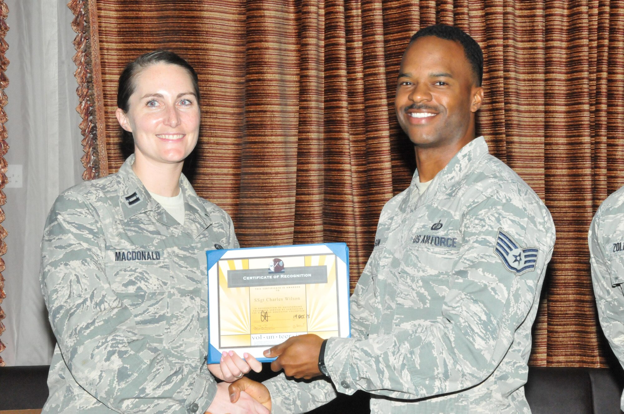 Staff Sgt. Charles Wilson, 379th Expeditionary Construction Squadron contracting officer, receives his certificate of recognition Dec. 29 at Al Udeid Air Base, Qatar. Wilson was recognized as a Presidential Volunteer Service Award winner, for volunteering more than 500 hours in the community. (U.S. Air Force photo by Tech. Sgt. Terrica Y. Jones/Released)