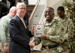 Pat McCormick, left, receives his DLA retirement plaque from DLA Distribution commander Army Brig. Gen. Richard Dix in honor of his 38-year career with the Federal government.  