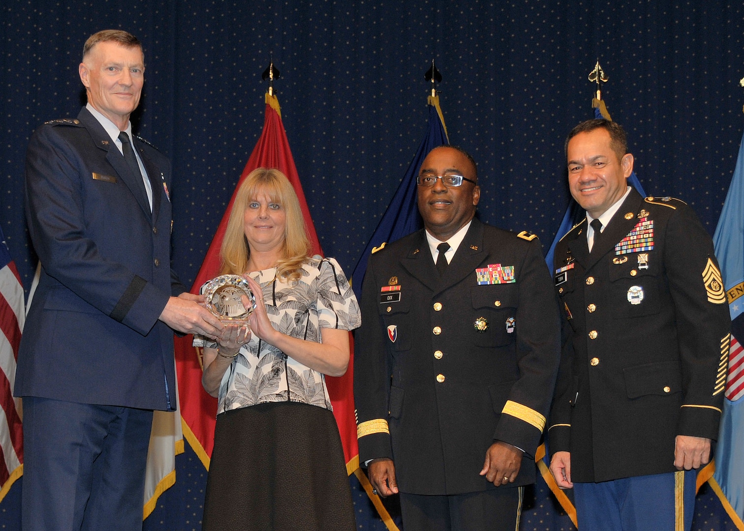 DLA director Air Force Lt. Gen. Andy Busch, left, presents Bikki Queen, secretary for the Preservation, Packaging, Packing, and Marking Branch at Defense Logistics Agency Distribution Oklahoma City, Okla., with one of the top Ten Outstanding DLA Personnel of the Year awards for 2015 awards at the 48th annual employee recognition ceremony Dec. 10. Distribution’s commander Army Brig. Gen. Richard Dix, second from right, and DLA’s Senior Enlisted Leader Army Command Sgt. Maj. Charles Tobin, right, were also on-hand to present the award.