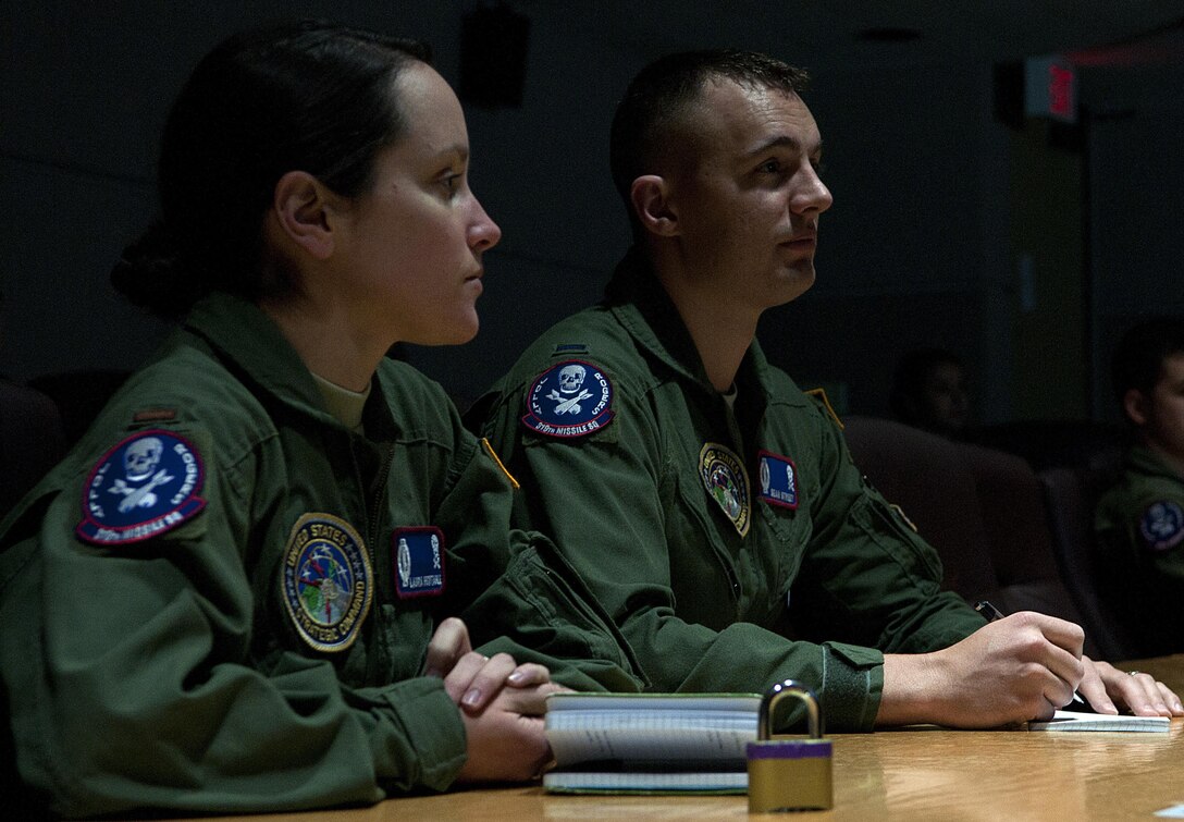 Air Force 1st Lt. Sean Street, right, and 2nd Lt. Laura Huxtable, 319th Missile Squadron, listen to a briefing inside the 90th Operations Group on F.E. Warren Air Force Base, Wyo., Dec. 31, 2015, as they prepare to depart to the missile field to stand alert into the New Year. During their alert mission the two missileers received a phone call from Gen. Paul Selva, vice chairman of the Joint Chiefs of Staff, wishing them a happy New Year. 