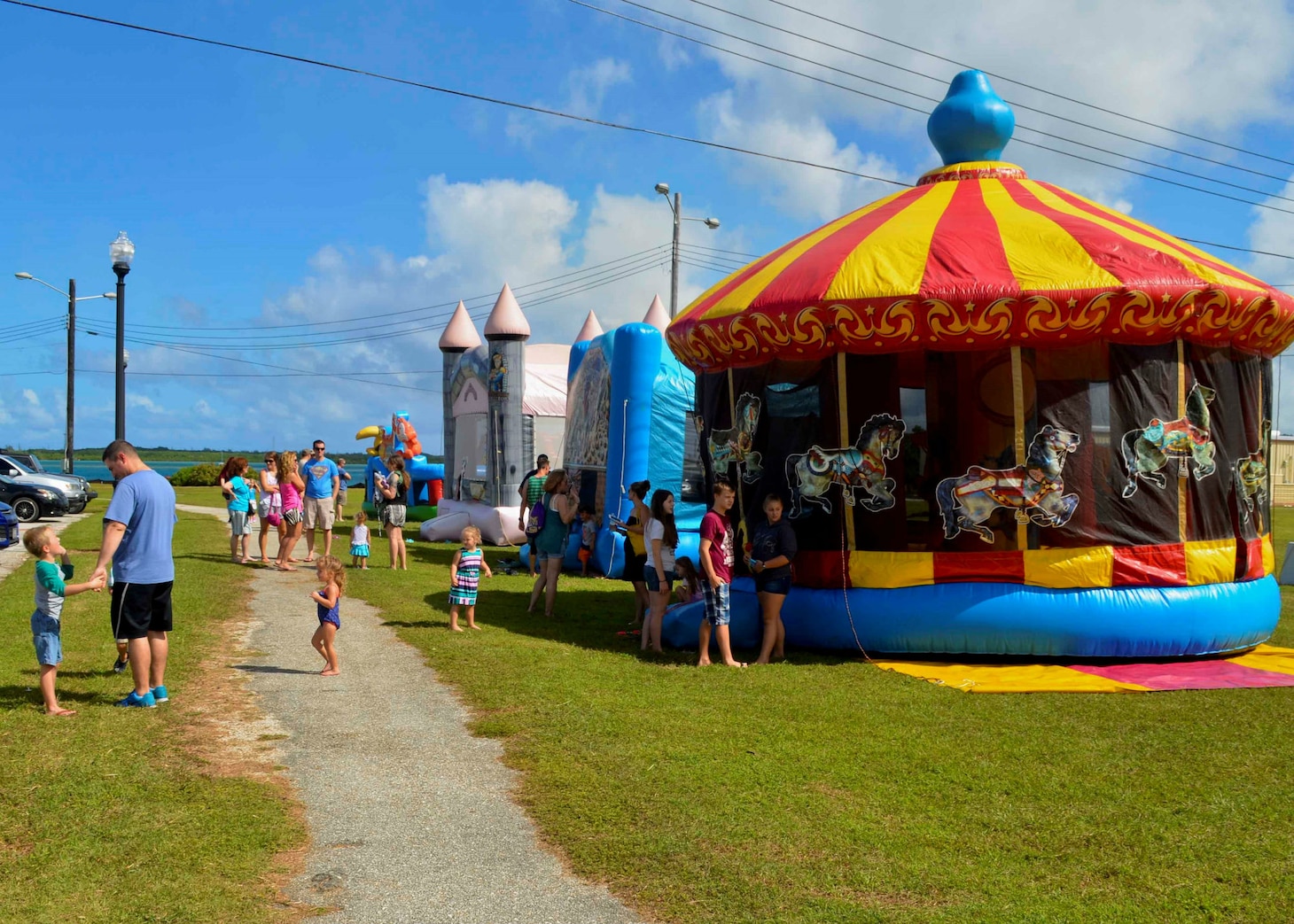 SANTA RITA, Guam (Dec. 19, 2015) Sailors and family members gather around bouncy houses during the first ever Team 15 Day event December 19.  Team 15 Day, hosted by Submarine Squadron 15, is an event that brings together Sailors and families from the submarine community on Guam to educate them on Navy support services and acclimate new arrivals to life on Guam.