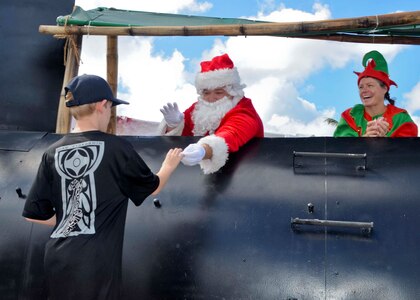 SANTA RITA, Guam (Dec. 19, 2015) A child receives candy from Santa Claus at the first Team 15 Day event December 19.  Team 15 Day, hosted by Submarine Squadron 15, is an event that brings together Sailors and families from the submarine community on Guam to educate them on Navy support services and acclimate new arrivals to life on Guam.