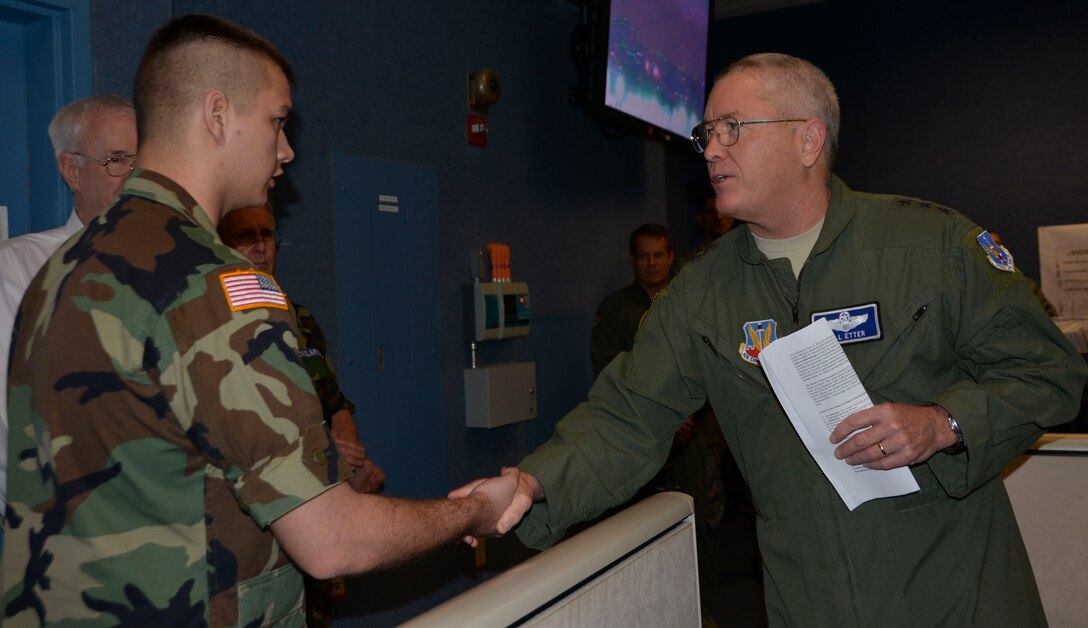 TYNDALL AIR FORCE BASE, Fla. - Lt. Gen. William Etter, Continental  U.S. North American Aerospace Defense Command Region – 1st Air Force (Air Forces Northern) commander, presents his commander’s coin for recognition of superior performance to Civil Air Patrol Cadet /Lieutenant Colonel  Alexander English, Central Florida Composite Squadron, during a CAP cadet tour of the 601st Air Operations Center Wednesday.  English is a CAP Bronze Medal of Honor  Recipient who distinguished himself by saving a cadet from imminent harm  when a tornado threatened the camper shelter where the cadet sought refuge. English  ran to the camper and brought the cadet to the safer shelter of a van only minutes before the tornado struck and flipped the camper. English and the other cadets were visiting the 601st AOC as part of their annual week-long winter encampment event designed provide an in-depth orientation to the Civil Air Patrol and the United States Air Force. (Air Force Photo Released/Mary McHale)