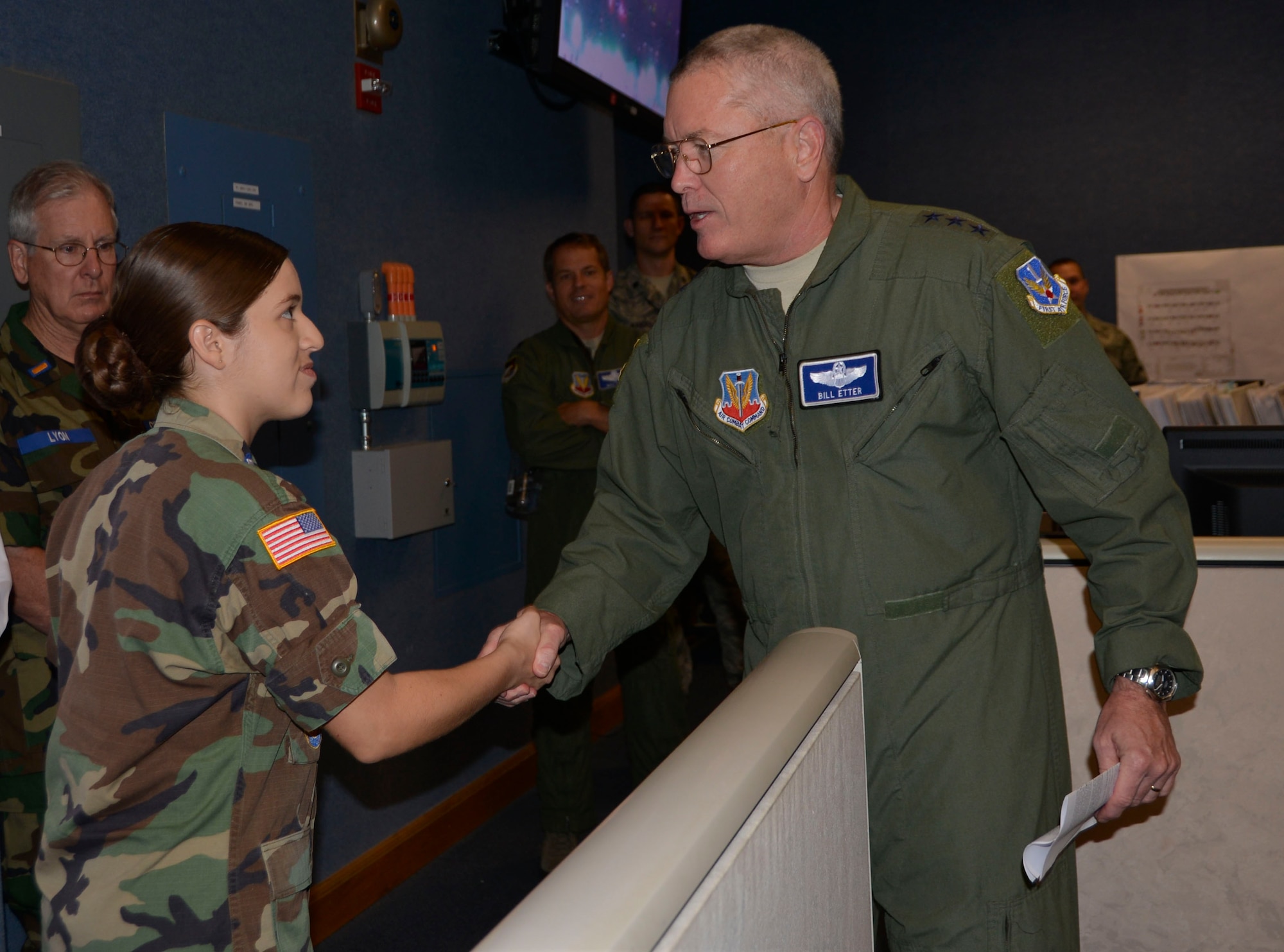 TYNDALL AIR FORCE BASE, Fla. - Lt. Gen. William Etter, Continental  U.S. North American Aerospace Defense Command Region – 1st Air Force (Air Forces Northern) commander, presents his commander’s coin for recognition of superior performance to Civil Air Patrol Cadet/Colonel Iriolexis Encalada, Pines-Miramar Cadet Squadron, during a CAP cadet tour of the 601st Air Operations Center Wednesday. Encalada distinguished herself as the newest Carl A. Spaatz Award recipient in CAP’s Florida Wing, an achievement accomplished by less than one percent of cadets in the program.  Encalada and the other cadets were visiting the 601st AOC as part of their annual week-long winter encampment event designed provide an in-depth orientation to the Civil Air Patrol and the United States Air Force. She also served as the cadet commander of the encampment. (Air Force Photo Released/Mary McHale)