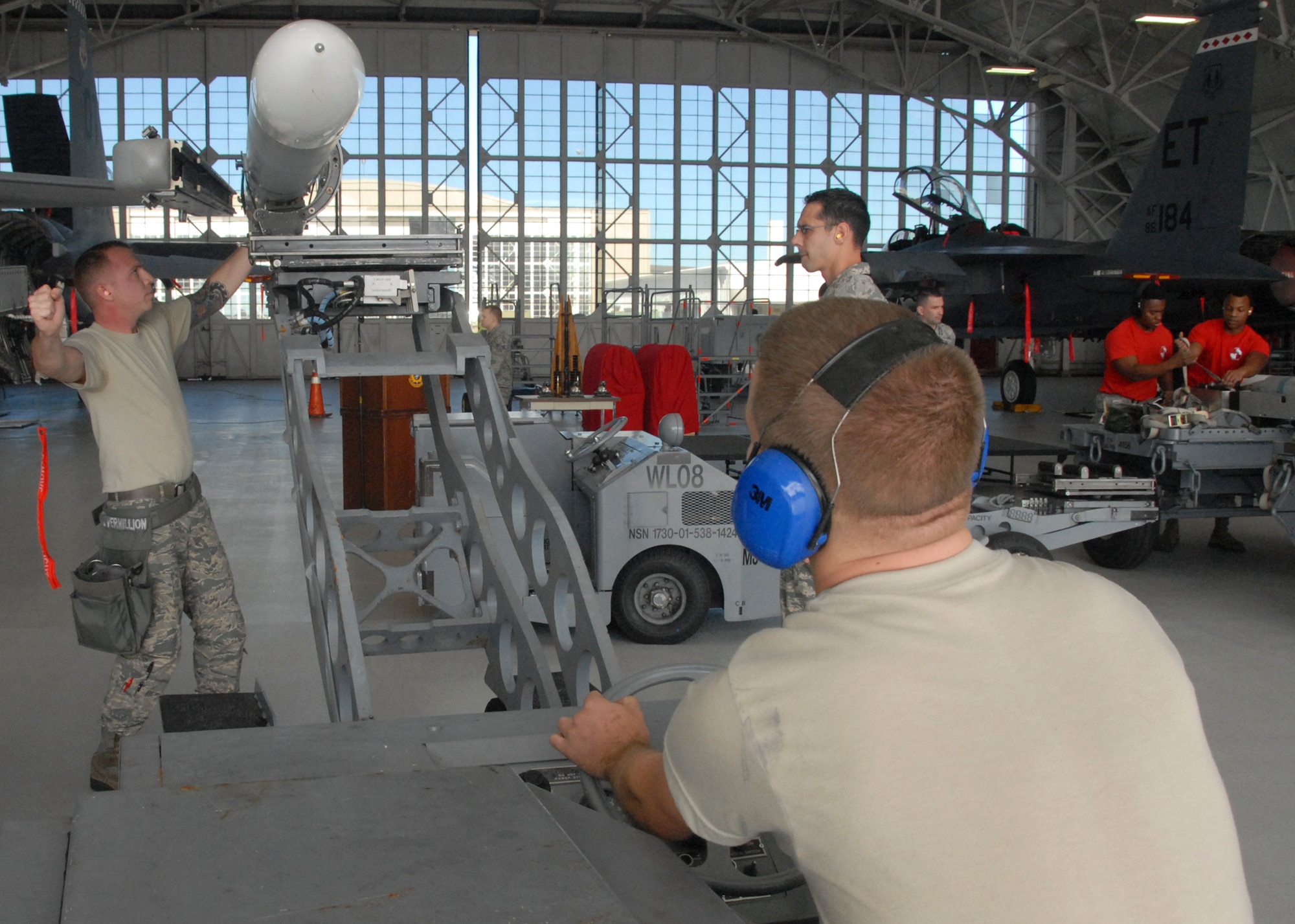 Staff Sgt. Jason Vermillion, of the 96th Aircraft Maintenance Squadron Blue, guides in Senior Airman Derron Ackermann while loading an AIM-120 missile onto the F-16 Fighting Falcon, during the fourth quarter weapons loadcrew competition Dec. 18 at Eglin Air Force Base, Fla.  Vermillion, Ackermann and Airman 1st Class William Walters represented the Blue AMU. The Blue team defeated the Red team in the competition. (U.S. Air Force photo/Kevin Gaddie)