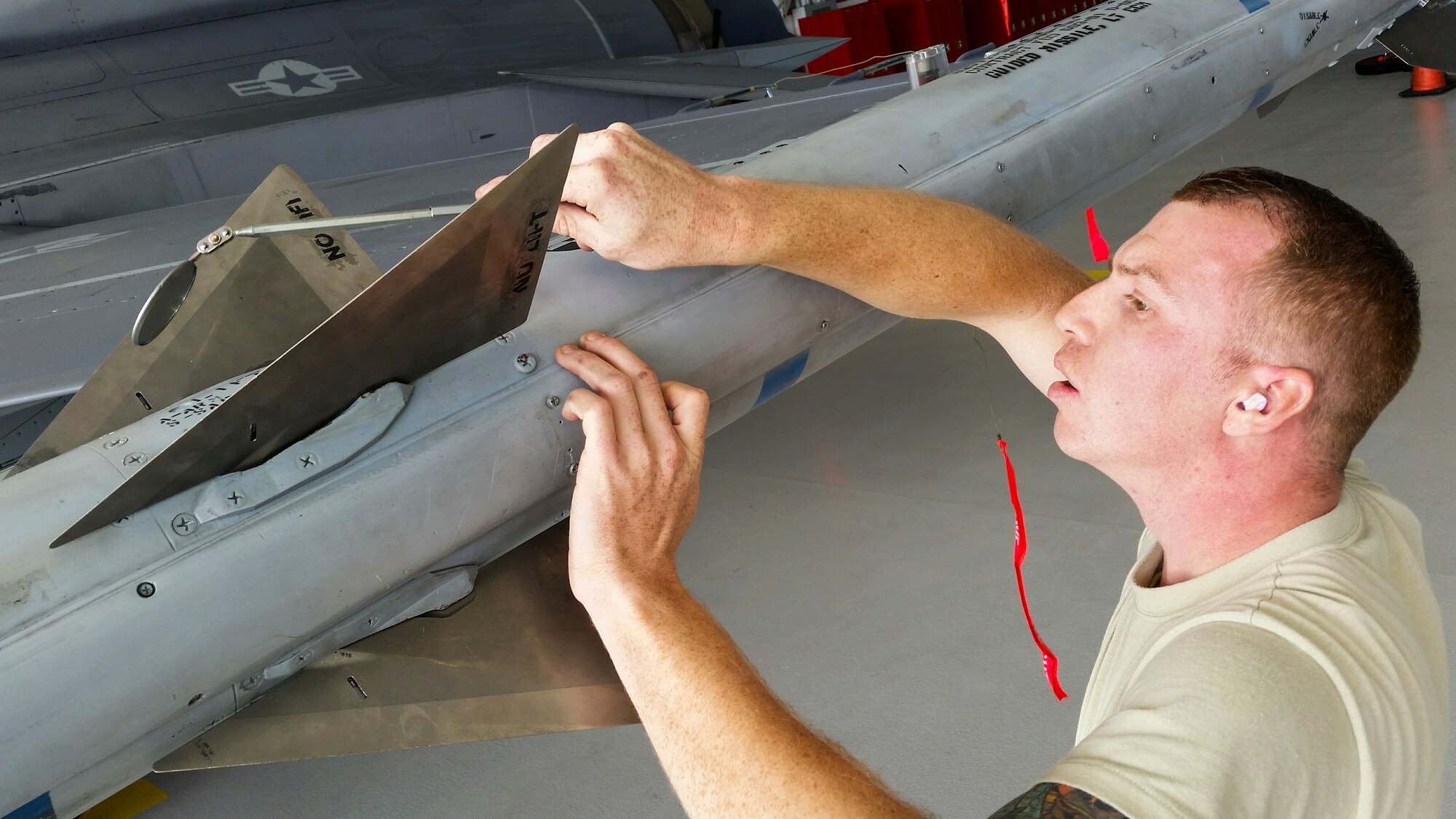 Staff Sgt. Jason Vermillion, of the 96th Aircraft Maintenance Squadron Blue, ensures the wings are properly installed on the AIM-120 missile and secured onto the F-16 Fighting Falcon, during the fourth quarter weapons loadcrew competition Dec. 18 at Eglin Air Force Base, Fla.  Vermillion, Senior Airman Derron Ackermann and Airman 1st Class William Walters represented the Blue AMU. The Blue team defeated the Red team in the competition. (U.S. Air Force photo/Kevin Gaddie)