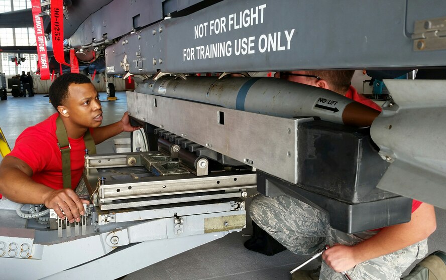 Staff Sgt. Tyson Dunston, of the 96th Aircraft Maintenance Squadron Red, guides a GBU-39 small diameter bomb into the BRU-61 rack of the F-15 Strike Eagle, during the fourth quarter weapons loadcrew competition Dec. 18 at Eglin Air Force Base, Fla. Dunston, Airman 1st Class Aaron Shirk and Airman 1st Class Aaron Jennings represented the Red AMU. The Red team lost to the Blue team in the competition. (U.S. Air Force photo/Kevin Gaddie)