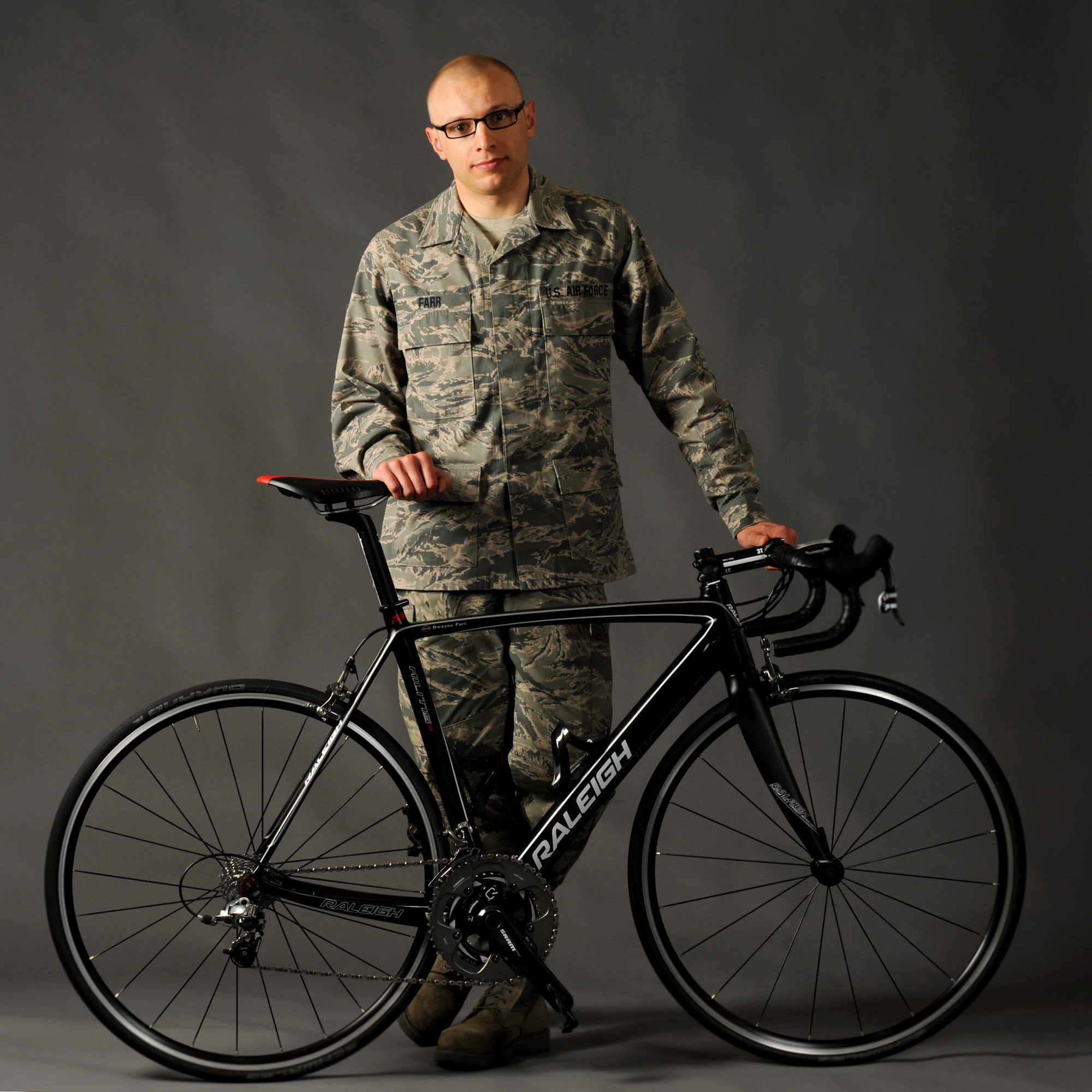 Oregon Air National Guard Tech. Sgt. Dwayne Farr, assigned to the 142nd Fighter Wing Aircraft Maintenance Squadron, poses with one of his bicycles during a photo shoot at the air base Public Affairs office, Portland Air National Guard Base, Ore., April 7, 2013. Farr has been training and racing as an endurance cyclist during the past four years and was part of the Military World Games in Mungyeoung, Korea, October 6, 2015. (U.S. Air National Guard photo by Tech. Sgt. John Hughel, 142nd Fighter Wing Public Affairs/Released)