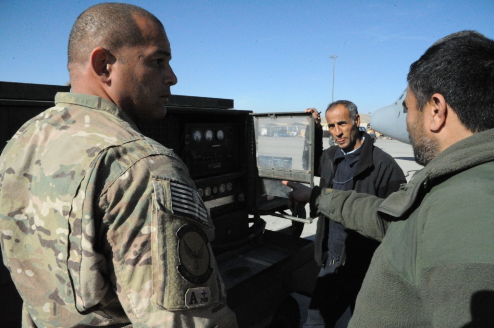 Tech. Sgt. Hector Ayala, Train, Advise, Assist Command-Air fixed wing advisor teaches future Afghan C-130 maintainers how to connect external power to the aircraft with a Dash-86 generator. The training is part of C-130 lead-in training that will better prepare the students for formal training in the United States. The Afghan students study both aircraft familiarization and the English language. (US Air Force photo by Senior Master Sgt. J. LaVoie/Released)