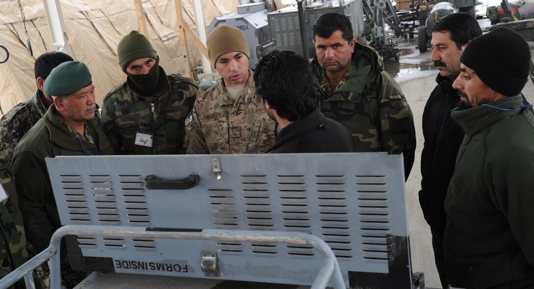 Staff Sgt. Jose Cartagena, Train, Advise, Assist Command-Air fixed wing advisor explains the proper way to conduct an operators inspection on a new generation heater. Aerospace ground equipment is one of the areas future Afghan C-130 maintainers are being taught during C-130 maintenance lead-in training. Afghan maintainers are already performing much of the work on their helicopter fleet, but are just beginning C-130 maintenance. (US Air Force photo by Senior Master Sgt. J. LaVoie/Released)