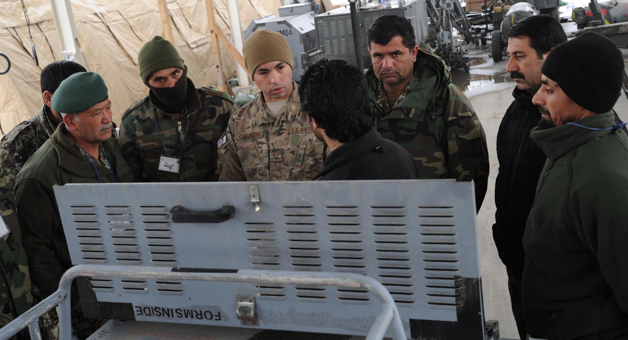 Staff Sgt. Jose Cartagena, Train, Advise, Assist Command-Air fixed wing advisor explains the proper way to conduct an operators inspection on a new generation heater. Aerospace ground equipment is one of the areas future Afghan C-130 maintainers are being taught during C-130 maintenance lead-in training. Afghan maintainers are already performing much of the work on their helicopter fleet, but are just beginning C-130 maintenance. (US Air Force photo by Senior Master Sgt. J. LaVoie/Released)