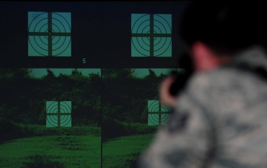Staff Sgt. Ryan gulley fires at a simulated target Jan. 26, 2015, at Joint Base Langley-Eustis, Va. In addition to realistic scenarios, the new weapons simulator also includes target practice and gives real-time feedback to help improve form and technique. Gulley is a 633rd Security Forces Squadron training instructor. (U.S. Air Force photo/Airman 1st Class Areca T. Wilson)