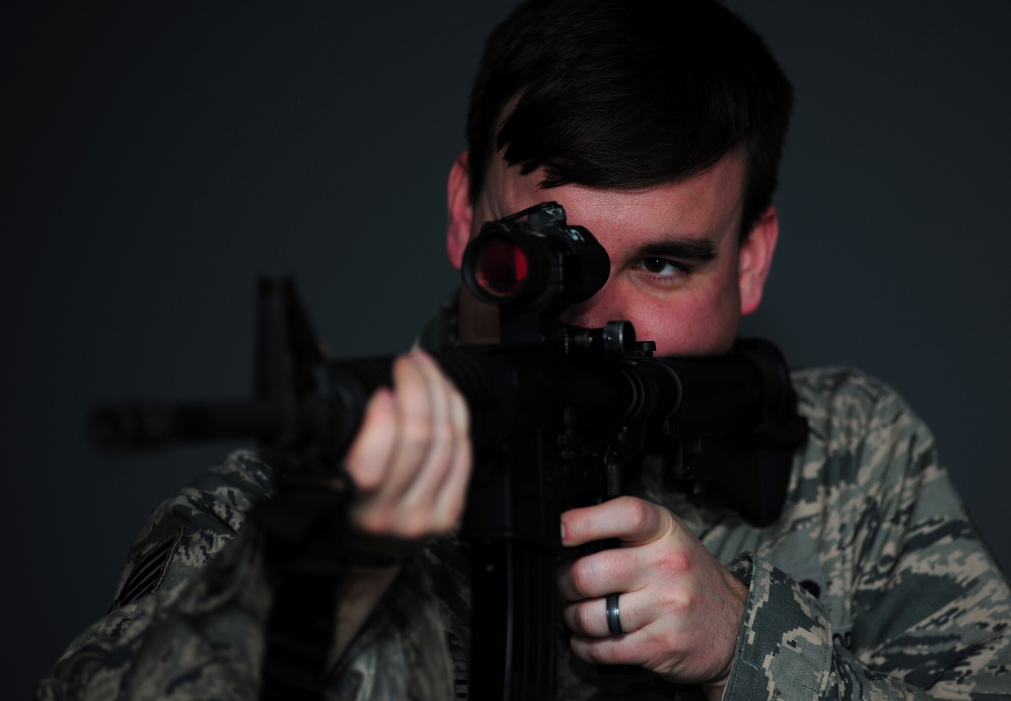 Staff Sgt. Ryan Gulley fires at a simulated target Jan. 26, 2015, at Joint Base Langley-Eustis, Va. The new firearms simulator allows Airmen to gain real-world knowledge and experience through projections of real-life scenarios. Gulley is a 633rd Security Forces Squadron training instructor. (U.S. Air Force photo/Airman 1st Class Areca T. Wilson)