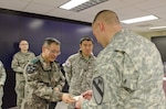 CAMP CASEY, South Korea (Jan. 27, 2015) - Lt. Col. Ill-sue Lee (left), the Republic of Korea Army Support Group Commander, passes his card to Col. Sean Bernabe, the commander of 2nd Armored Brigade Combat Team, 1st Cavalry Division, Fort Hood, Texas, during an operations plan brief.  Bernabe came to Camp Casey, South Korea, as part of a pre-deployment site survey for his unit's upcoming rotation to South Korea. 