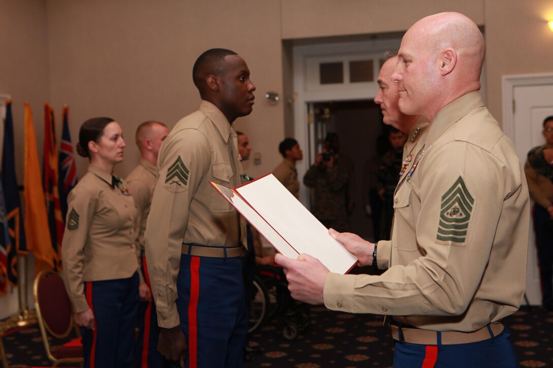 Gen. Joseph F. Dunford, the 36th Commandant of the Marine Corps, and Sgt. Maj. Micheal P. Barrett, the 17th Sergeant Major of the Marine Corps, meritoriously promote Sgt. Quassie I. Swan to the rank of Staff Sgt. during the 2014 Combined Awards Ceremony at the Clubs of Quantico in Quantico, Va., Jan. 29, 2014. (U.S. Marine Corps photo by Sgt. Marionne T. Mangrum)