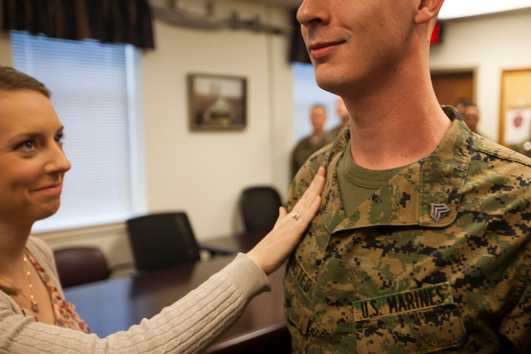 Danielle Olmsted, left, native of Brandon, Miss., smiles as she pins her husband, U.S. Marine Corps Sgt. Todd Olmsted, 22nd Marine Expeditionary Unit Marine air-ground task force planner and native of Brandon, Miss., to his current rank during a promotion ceremony at Marine Corps Base Camp Lejeune, N.C., Feb. 2, 2015. (U.S. Marine Corps photo by Sgt. Austin Hazard/Released)