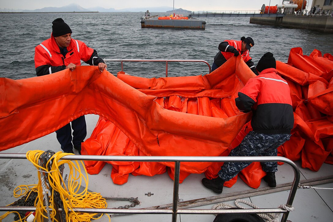 The Facility Response Team aboard Marine Corps Air Station Iwakuni, Japan, properly stage containment boom that is used as a temporary floating barrier for oil spill response, containment and recovery operations, Jan. 28, 2015. The team conducted a weeklong training evolution to requalify and refresh U.S. Navy and Marine Corps personnel on oil spill response procedures, multiple containment methods and successful recovery maneuvers, Jan. 25-30, 2015.